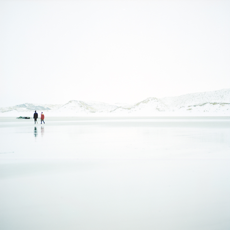 Paysage ciel couleur bleu blanc bord de mer deux marcheurs et dune enneigée arrière plan