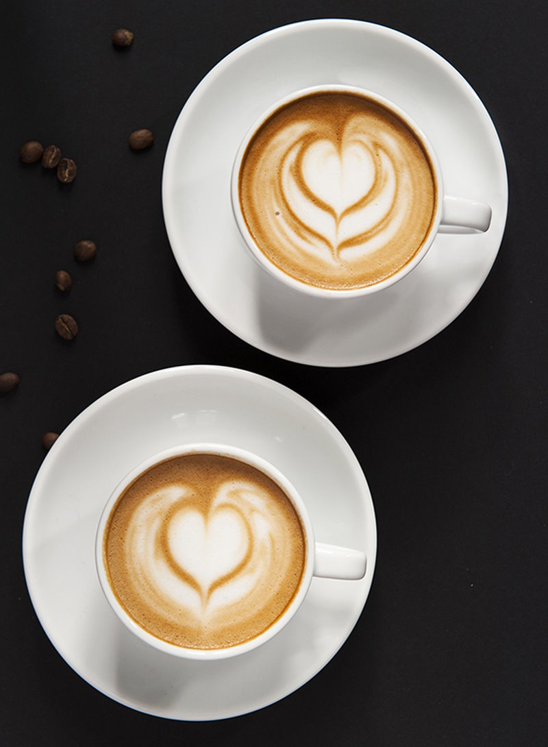 Photo culinaire deux tasses de cafe mousse en forme de coeur